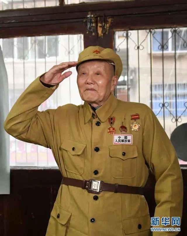 张富清穿着老式军装敬军礼（2019年3月31日摄）。新华社记者程敏摄
